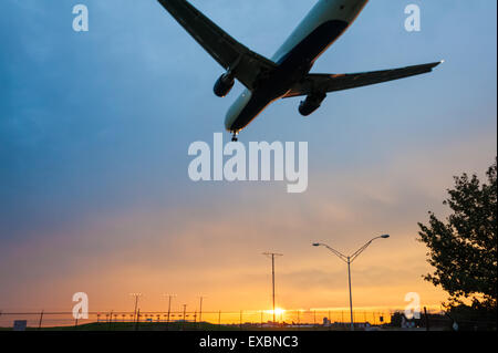 Delta Airlines Jet fliegen niedrig wie es nähert sich der Start- und Landebahn am Atlanta International Airport unter einer bunten Sonnenuntergang Himmel. (USA) Stockfoto