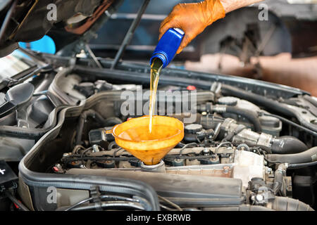 Füllen Sie Öl zu einem auto motor mit einem Trichter