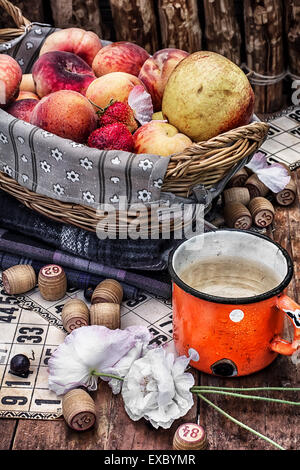 Zubehör Picknick bestehend aus Pfirsiche, Äpfel und Lottospiele. Foto getönt. Stockfoto