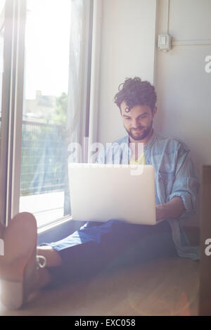 hübsche Hipster der moderne Mensch Designer arbeiten Zuhause mit Laptop zu Hause Stockfoto