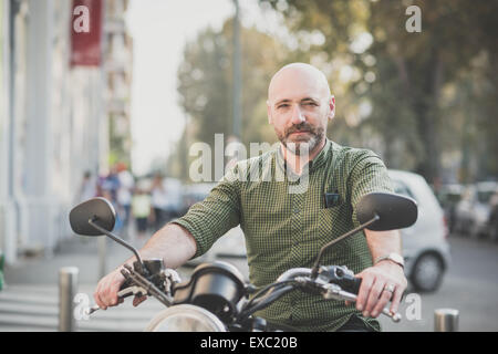 hübscher Mann mittleren Alters Motorradfahrer in der Stadt Stockfoto