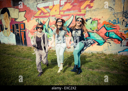 drei schöne Freunde authentisch im urbanen Wettbewerb, Musik hören Stockfoto