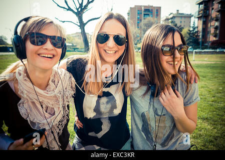 drei schöne Freunde authentisch im urbanen Wettbewerb, Musik hören Stockfoto