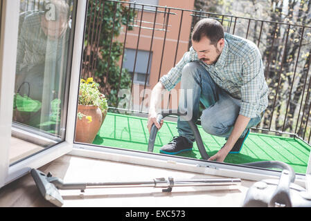 schöne stilvolle Mann mit Hoover zu Hause Stockfoto