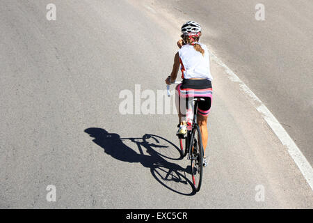 Radfahrer-Frau mit dem Fahrrad auf einer Landstraße Stockfoto