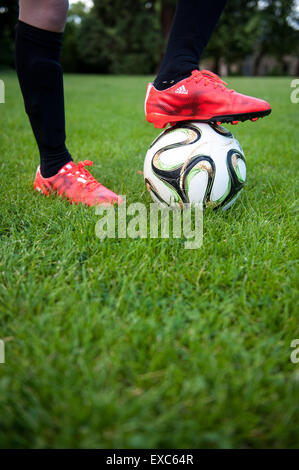 Nahaufnahme eines kleinen Jungen mit seinem Fuß auf einem Fußball Stockfoto