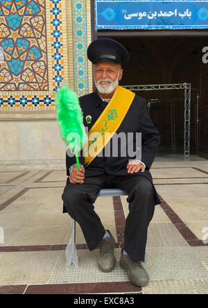 Wache mit einem grünen Staubwedel an der Shah-e-Cheragh-Mausoleum, Fars Provinz, Shiraz, Iran Stockfoto