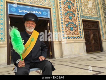 Wache mit einem grünen Staubwedel an der Shah-e-Cheragh-Mausoleum, Fars Provinz, Shiraz, Iran Stockfoto