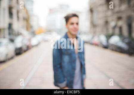 unscharfen Hintergrund junge hübsche dunkle Alternativmodell Mann in der Stadt Stockfoto