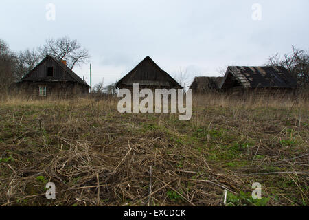 das alte überwucherte Haus gebaut von Protokollen im einsamen Dorf Stockfoto