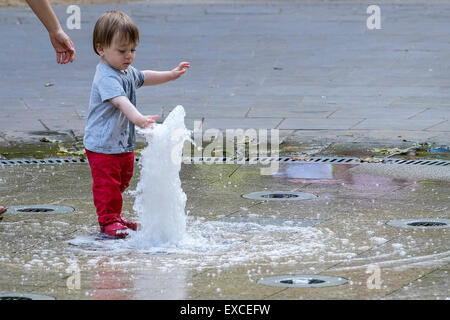 Russell Square Gardens, London, UK. 11. Juli 2015.    Ein Kleinkind entweicht die Wärme in London heute durch Abkühlung in den Brunnen in Russell Sqauare Gärten.  Bildnachweis: Gordon Scammell/Alamy Live-Nachrichten. Stockfoto