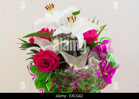 feines Bouquet von frischen Lilien und Rosen als Geschenk Stockfoto