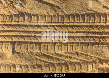 Spuren des Rades treten auf einem Sandstrand Stockfoto