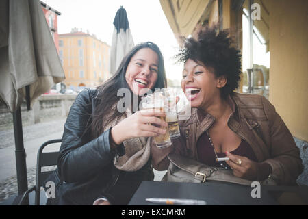 zwei multiethnischen schöne junge Frau Schwarz und kaukasischen Spaß trinken ein Bier in der Stadt Stockfoto