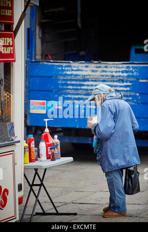 Eine Frau kauft einen Snack aus einem Take-Away auf Liverpool Straße im Stadtzentrum von Manchester Snack Fisch Chips Burger Essen Tomaten Ketchup s Stockfoto