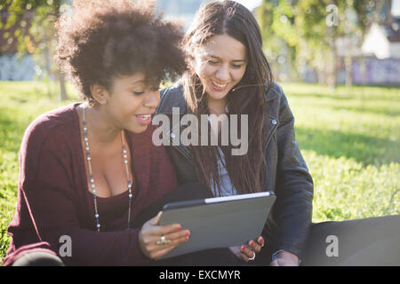 zwei multiethnischen schöne junge Frau Schwarz und kaukasischen mit einem Tablet in der Stadt Stockfoto