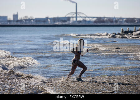 Menschen nehmen an der jährlichen Polar Bear Plunge in Bradford Beach am Lake Michigan in Milwaukee, Wisconsin am Neujahrstag. Stockfoto