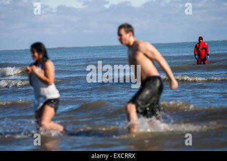 Menschen nehmen an der jährlichen Polar Bear Plunge in Bradford Beach am Lake Michigan in Milwaukee, Wisconsin am Neujahrstag. Stockfoto