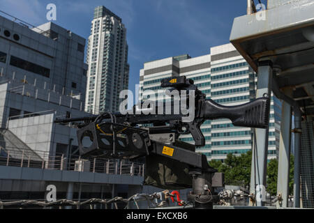 Gimpy - ein Allzweck-Maschinengewehr im Fokus mit Schwerpunkt Gebäude am South Quay Docklands in London in der Ferne. Stockfoto