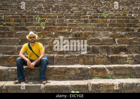 Hispanic Mann mit Hut sitzt am Ende der steilen alten Stein Schritte in Monte Alban, Mexiko Stockfoto