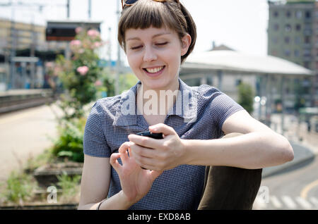 junge schöne Hipster Frau Eingabe Nachricht am Telefon in der Stadt Stockfoto