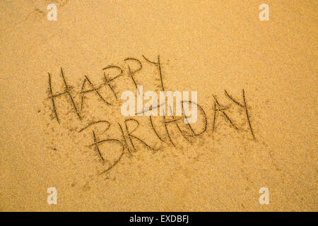Happy Birthday geschrieben in den Sand am Strand mit Plastilin Figur