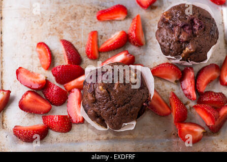 Schokoladen-Muffins mit Nüssen und Kirschen, Metall Hintergrund, Erdbeeren auf Seite, selektiven Fokus Stockfoto