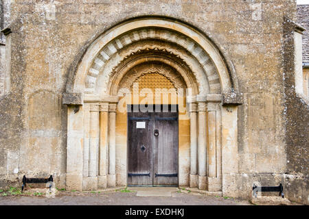 Englisch Dorf Guiting macht. Die Kirche von St. Michael. Das tympanon und die kunstvollen Steinmetzarbeiten arbeiten rund um die Tür Stockfoto