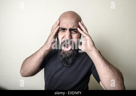 verzweifelte bärtiger Mann auf grauem Hintergrund isoliert Stockfoto