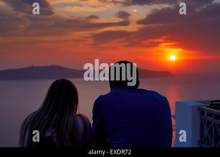 Ein paar erleben den Sonnenuntergang auf der Insel Santorini-Griechenland Stockfoto