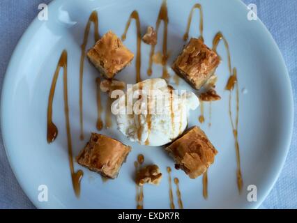 Teile des Baklava auf einen blauen Teller serviert mit Eis. Stockfoto