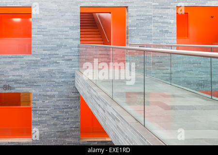 Laufsteg in einem modernen Gebäude mit mehreren Etagen und orange lackierte Passagen Stockfoto