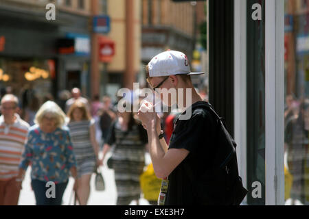 Junge Mann Beleuchtung Zigarette In A Tür Stockfoto