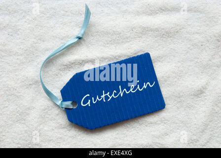 Gutschein bedeutet Gutschein auf Sand Blue Label Stockfoto