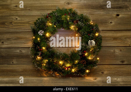 Adventskranz mit weißen Lichtern auf urigen Holzbrettern.  Gedämpfter Beleuchtung zu bringen Glanz der Lichter. Stockfoto