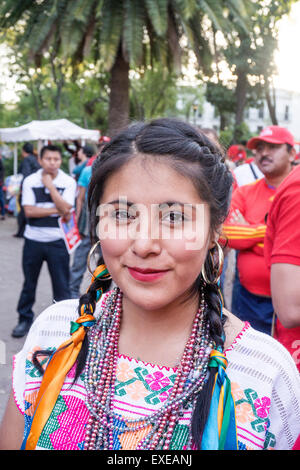 ziemlich mexikanisches Mädchen mit Bändern in ihre Zöpfe & tragen Tracht eingewebt zeichnet sich in Menge der Rothemden bei Rallye Stockfoto