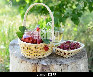 Still-Leben im Freien: einen Korb mit Erdbeeren und Marmelade Stockfoto