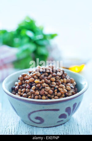 Linsen in Schüssel geben und auf einem Tisch Stockfoto