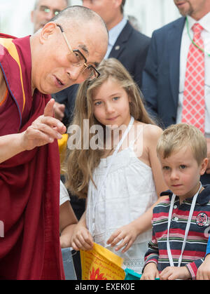 Frankfurt am Main, Deutschland. 13. Juli 2015. Der Dalai Lama wird von Kindern außerhalb der Museum Fuer Angewandte Kunst (Museum für angewandte Kunst) in Frankfurt am Main, 13. Juli 2015 begrüßt. Das geistliche Oberhaupt der Tibeter tourt die Region bis zur Ankunft Dienstag. Foto: BORRIS ROESSLER/Dpa/Alamy Live News Stockfoto