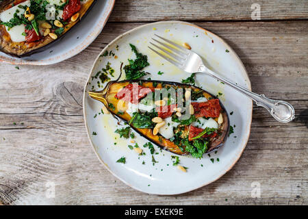 Gebratene Auberginen mit Ziegenkäse, knusprige Grünkohl, getrockneten Tomaten und Pinienkernen Stockfoto