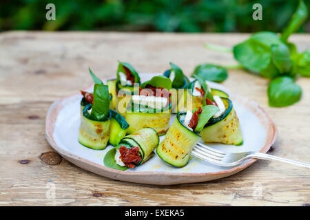 Zucchini-Röllchen mit Ziegenkäse, getrockneten Tomaten und Basilikum Stockfoto