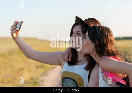 Zwei Mädchen im Teenageralter unter Selfie und Spaß im Freien haben Stockfoto