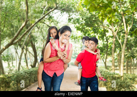 indische Eltern mit Kinder im Park genießen Sie Huckepack Reiten Stockfoto
