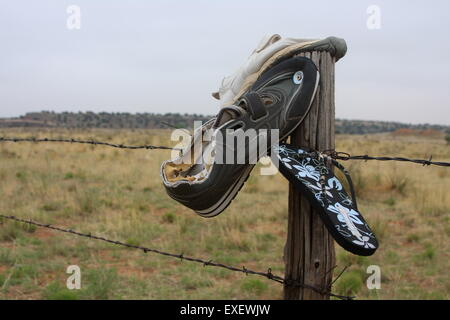 Schuhe, die an einen Zaun von der Seite der Route 66 in New Mexico USA genagelt Stockfoto