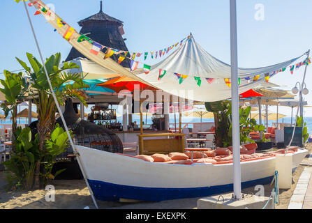 bequeme Sitze mit Kissen in einem Boot am Strand Stockfoto