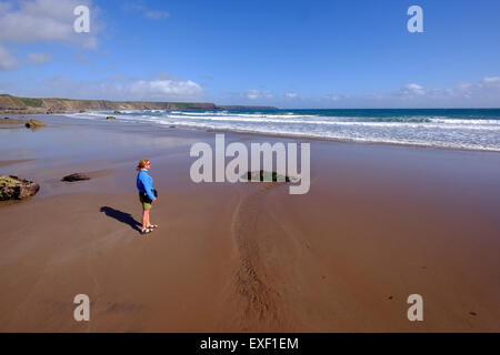 Weibliche Walker am Marloes Sandstrand an der Küste von Pembrokeshire, Wales UK Stockfoto