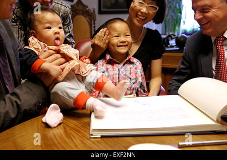 Freiberg / Deutschland. 9. Juli 2015. Die Geschwister aus China den Namen "Berg", das Mädchen und ihr Bruder "Frei" mit ihren Eltern Huixian Yang (C) und Hong She und Bürgermeister Bernd-Erwin Schramm (R) vor das silberne Buch der Stadt Freiberg, Deutschland, 9. Juli 2015 zu sitzen. Die Eltern der Kinder haben trafen sich während seines Studiums an der Freiberger Universität. Zu Ehren ihrer Gastgeber-Stadt beschlossen die Eltern, ihre Kinder nach der Stadt Freiberg zu benennen. Foto: Jan Woitas/Dpa/Alamy Live News Stockfoto