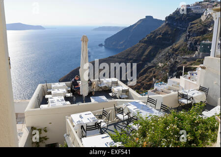 Ein junges Paar, Abendessen in einem Restaurant auf die Caldera mit dem Meer, Santorini, Griechenland. Stockfoto