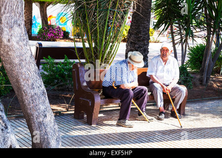 alte Männer reden setzte auf Bank in schattigen Schatten von Sonne-Walking-Stöcke fast blind Stockfoto