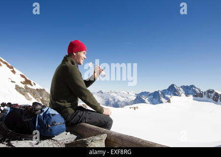 Männliche Wanderer Trinkwasser auf Aussichtsplattform, Jungfrauchjoch, Grindelwald, Schweiz Stockfoto